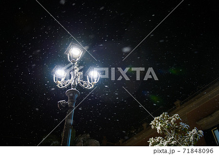 Old street lamp in snowfall during the winter night 71848096