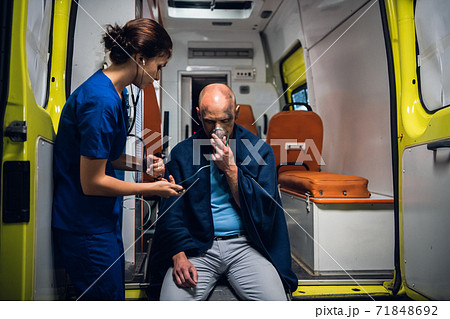 A young female paramedic on duty, taking care of an injured man 71848692