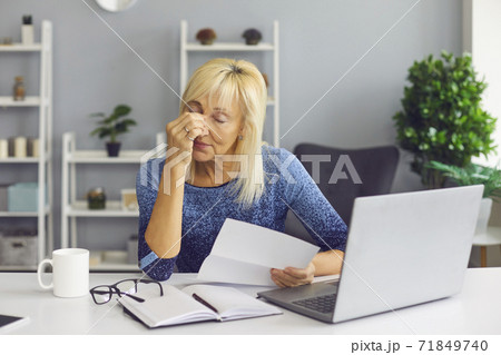 Tired senior woman receiving bankruptcy notification or rejection letter and crying 71849740