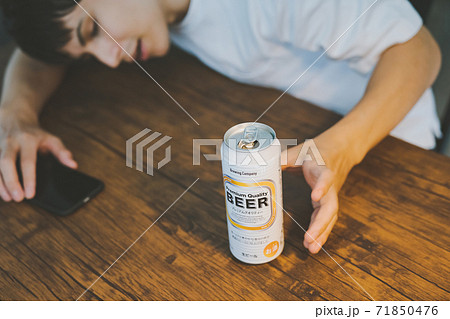 缶ビールを飲んで酔いつぶれる若者 缶ビールを飲んで酔いつぶれる若者 71850476
