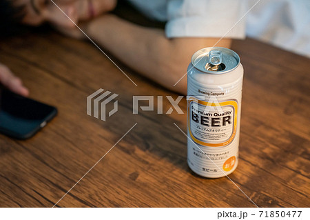 缶ビールを飲んで酔いつぶれる若者 71850477