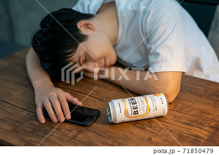 缶ビールを飲んで酔いつぶれる若者 缶ビールを飲んで酔いつぶれる若者 71850479