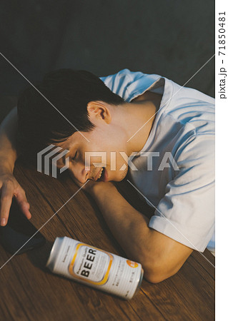 缶ビールを飲んで酔いつぶれる若者 71850481