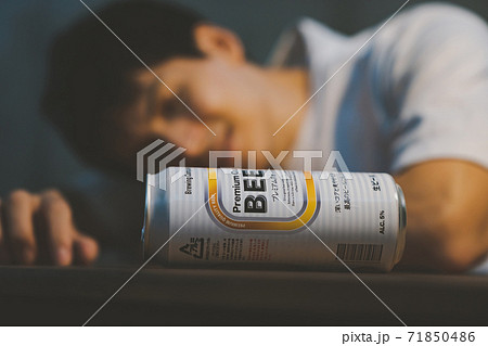 缶ビールを飲んで酔いつぶれる若者 71850486