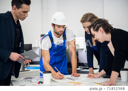 Construction team working with compasses and blueprints on an ar 71852568