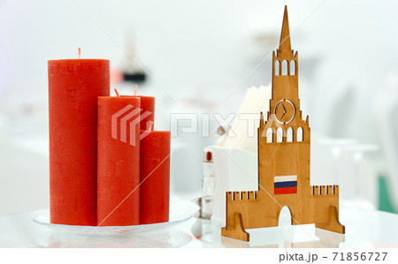 Served table with Russian topic decorated by red candles and wooden Kremlin Served table with Russian topic decorated by red candles and wooden Kremlin 71856727
