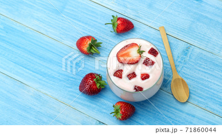 Strawberry yogurt on a blue wooden table. 71860044