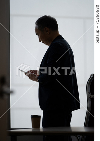 メールを見る後ろ姿の男性 71860680
