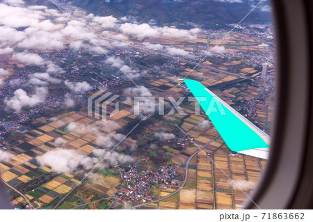 飛行機の窓から秋の山形盆地とウィングレットの写真素材