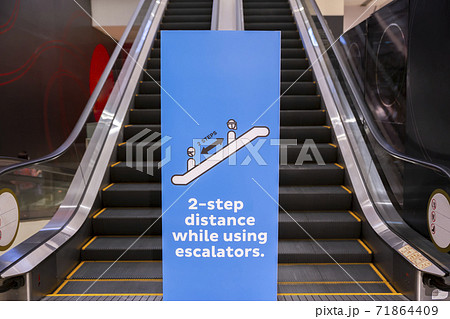 Social distancing sign for warning to keep social distance between each other to protect Coronavirus (CoVID-19) when on escalators.. 71864409