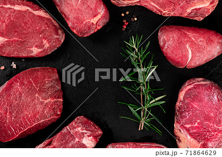 Meat, many different cuts, forming a frame on a dark slate background 71864629