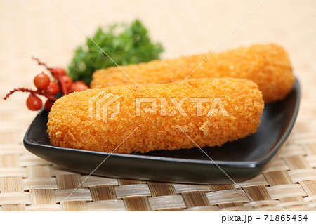 Korokke or Croquette the traditional japanese food two slice a deep-fried dish mashed potatoes or imo cheese. serving on the plate and two slice close up with bamboo woven background Korokke or Croquette the traditional japanese food two slice a deep-fried dish mashed potatoes or imo cheese. serving on the plate and two slice close up with bamboo woven background 71865464