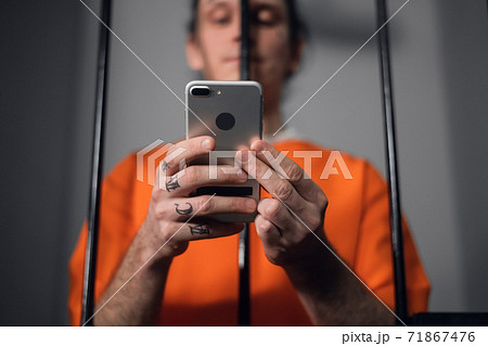 The criminal in the prison cell received a smartphone to communicate with relatives. 71867476