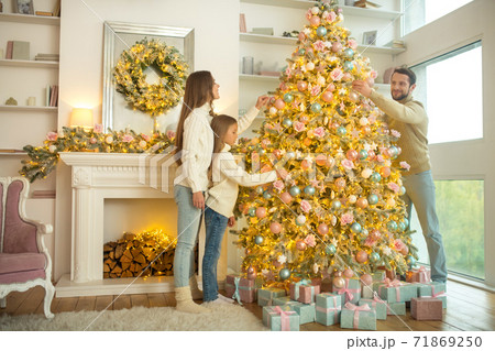 Young cute family decorating christmas tree together Young cute family decorating christmas tree together 71869250