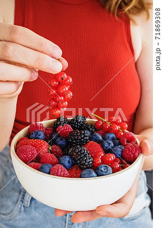 Female hands holding a bowl of delicious summer berries, Female hands holding a bowl of delicious summer berries, 71869308