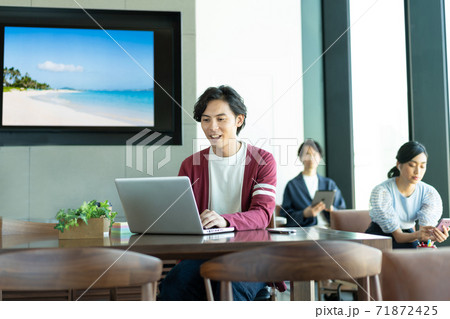 コワーキングスペースでパソコン作業をする若い男性 71872425