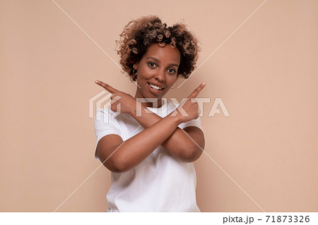 African woman filled with hesitations and doubts, points with index finger in differet sides African woman filled with hesitations and doubts, points with index finger in differet sides 71873326