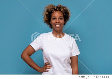 African young woman with shaggy hairstyle smiling cheerfully, feeling happy and carefree. African young woman with shaggy hairstyle smiling cheerfully, feeling happy and carefree. 71873333