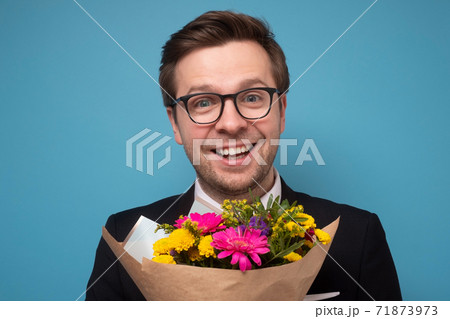 Smiling man holding a bouquet of flowers making a proposal. Smiling man holding a bouquet of flowers making a proposal. 71873973