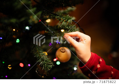 クリスマスツリーの飾りつけをする子供の手 71875822