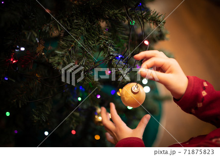 クリスマスツリーの飾りつけをする子供の手 71875823