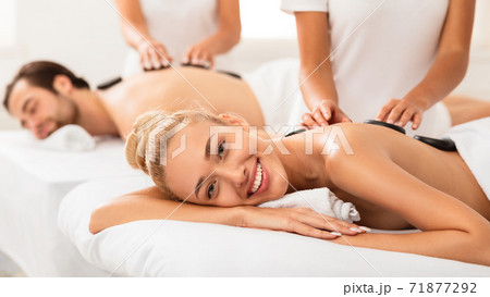 Happy Woman Getting Stone Massage On Couples Spa Procedure Indoors Happy Woman Getting Stone Massage On Couples Spa Procedure Indoors 71877292