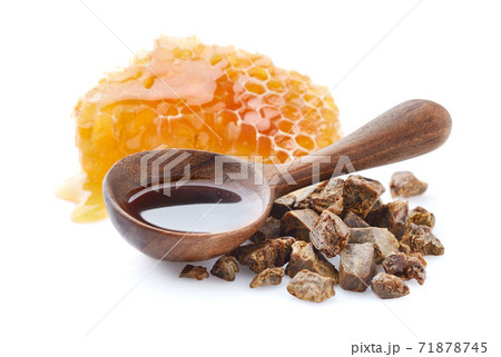 Propolis tincture in wooden spoon on white background Propolis tincture in wooden spoon on white background 71878745