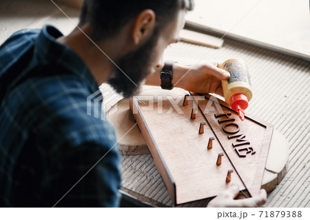 Woodworker applying glue to coards Woodworker applying glue to coards 71879388