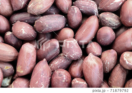 Peanut. A lot of small yellow nuts with brown peel. Background texture 71879792