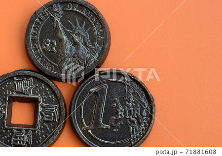 Three chocolate products in the form of Euro, USA and Japan coins lie on an orange plastic background. A model of cash coins in an edible form Three chocolate products in the form of Euro, USA and Japan coins lie on an orange plastic background. A model of cash coins in an edible form 71881608
