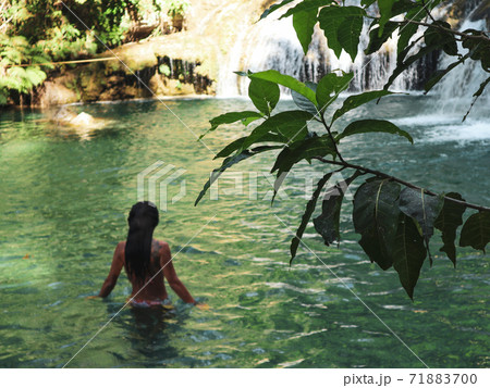 woman swimming alone at the tropical wild nature of waterfalls, cambugahay falls in Siquijor Island in Philippines 71883700
