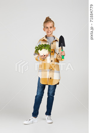 Little girl watering plants in a flower pot Little girl watering plants in a flower pot 71884779