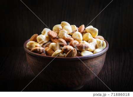 Mix of cashews and almonds in clay plate Mix of cashews and almonds in clay plate 71886018
