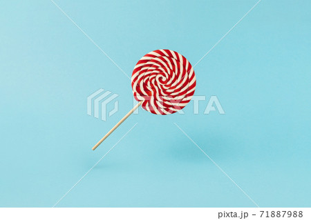 Colorful lolipop on blue background, wooden stick, red and white spiral, childhood sweets, Christmas concept 71887988