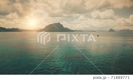 Alone yacht at ocean bay coast with sun silhouette of mountain islands at panorama aerial shot 71889771