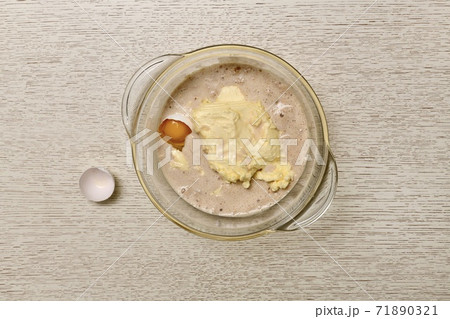 Bowl with kneaded ingredients, yeast, milk, eggs, butter for dough. Nearby shell.  71890321