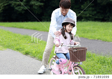 自転車の補助輪を取って練習をする親子 71891699