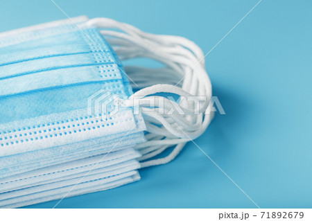 Medical protective masks on a blue background are stacked. Medical protective masks on a blue background are stacked. 71892679