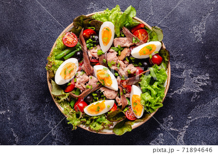 salad Nicoise with tuna, eggs, green beans, tomatoes,  olives, lettuce and anchovies 71894646