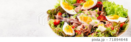 salad Nicoise with tuna, eggs, green beans, tomatoes,  olives, lettuce and anchovies 71894648