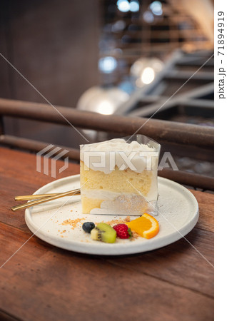 Coconut vanilla cake with whipped cream and berry fruits on plate 71894919