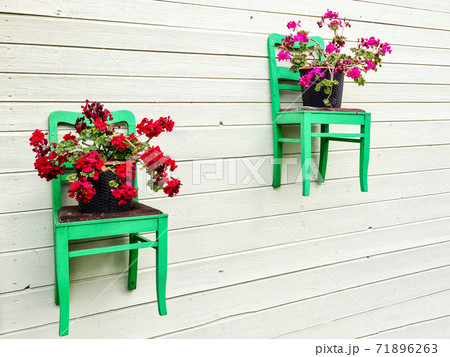 wooden chairs attached to the outer wall of the house as flower pot holders 71896263
