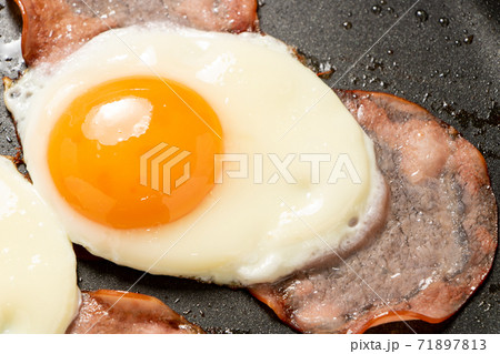 フライパンで焼かれたハムエッグ。 71897813