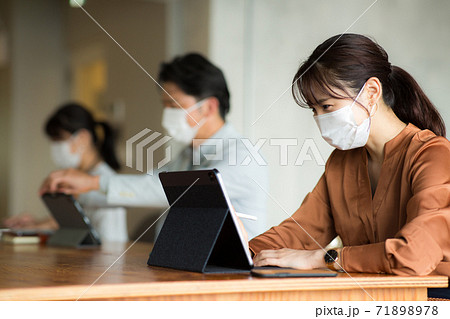 マスクをして離れて仕事をする 71898978