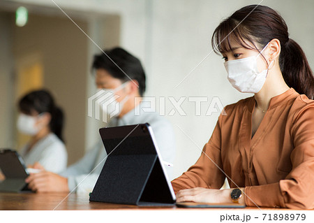 マスクをして離れて仕事をする 71898979