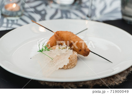 chef serving juicy meat cutlets with a crisp on a ceramic plate with rice chef serving juicy meat cutlets with a crisp on a ceramic plate with rice 71900049