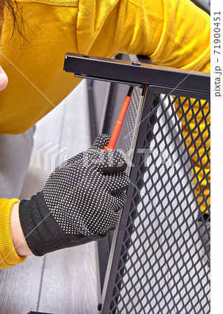 Professional assembler is screwing bolts of metal frame of flat-pack furniture. Professional assembler is screwing bolts of metal frame of flat-pack furniture. 71900451