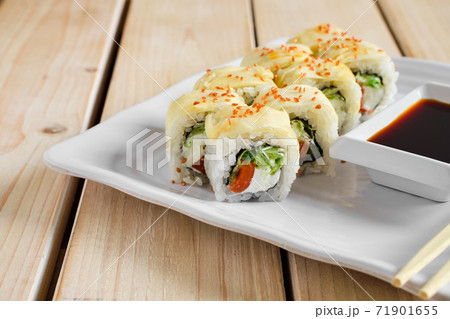 Portion of rolls with salmon, cucumber and cheese in marinated ginger dressing with golden sesame Portion of rolls with salmon, cucumber and cheese in marinated ginger dressing with golden sesame 71901655