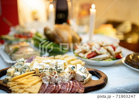 Cheese and meat platter on a wooden board on a festive table. View from above. Cheese and meat platter on a wooden board on a festive table. View from above. 71903247