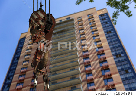 Construction crane hook with multi-storey building under construction (new residential complex) on the background. Construction site upon renovation program in Cheryomushki district, Moscow, Russia 71904393